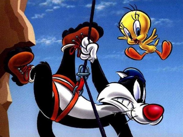Sylvester climbing a mountain with Tweety flying by