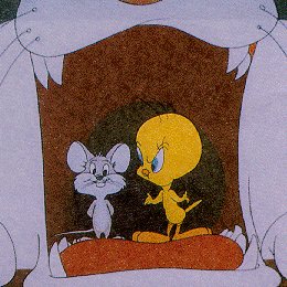 Tweety looks angry at a mouse, both in Sylvesters mouth